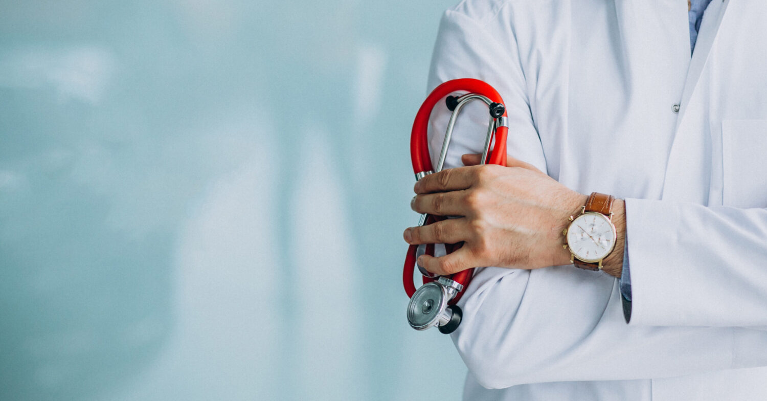 Young handsome physician in a medical robe with stethoscope